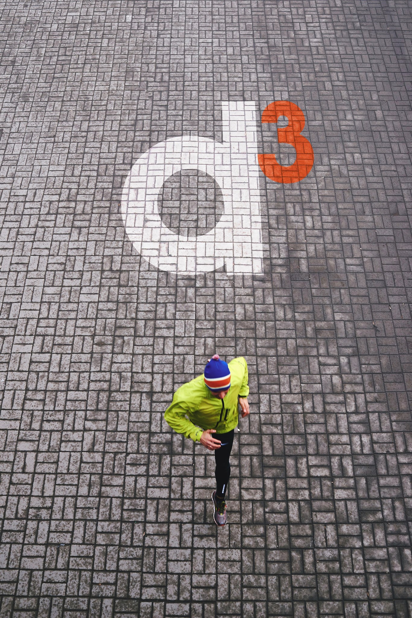 Man running over brick road with d3 logo
